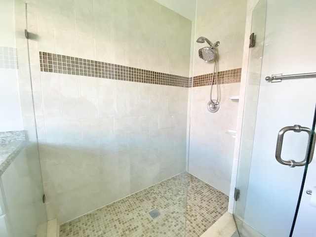 bathroom with tile patterned flooring and a shower with shower door