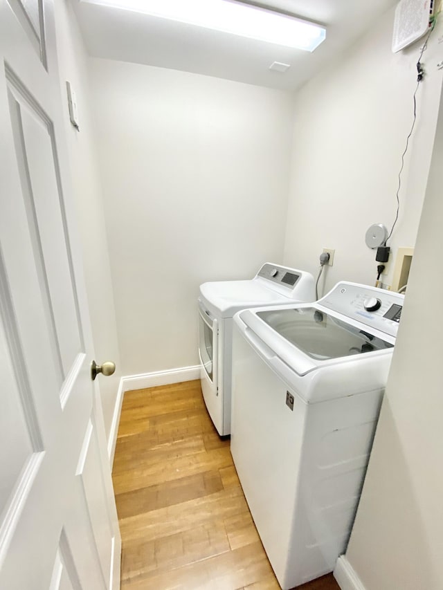 clothes washing area featuring washer and dryer and light wood-type flooring