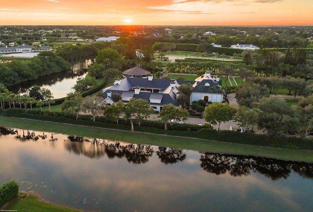 aerial view at dusk featuring a water view