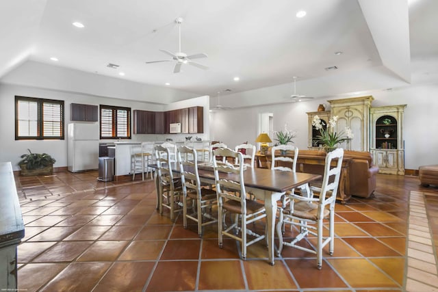 dining area with dark tile patterned floors and ceiling fan