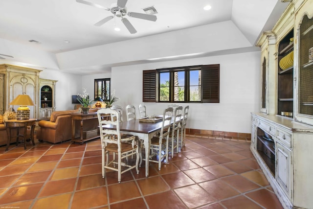 dining area with lofted ceiling, dark tile patterned flooring, and ceiling fan