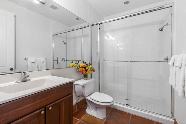 bathroom with toilet, vanity, a shower with door, and tile patterned flooring