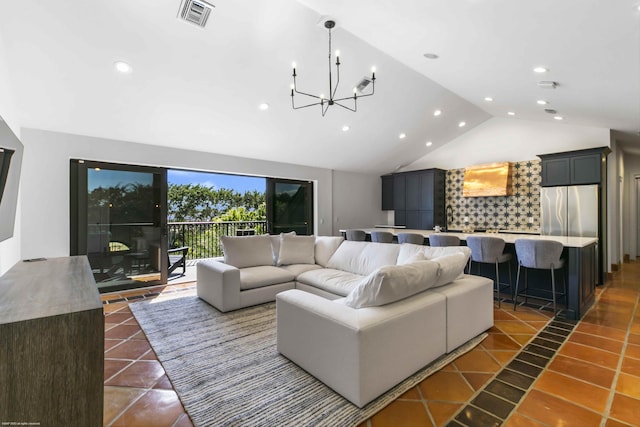 tiled living room featuring an inviting chandelier and vaulted ceiling