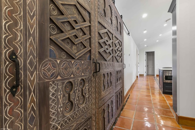 corridor featuring lofted ceiling and tile patterned floors