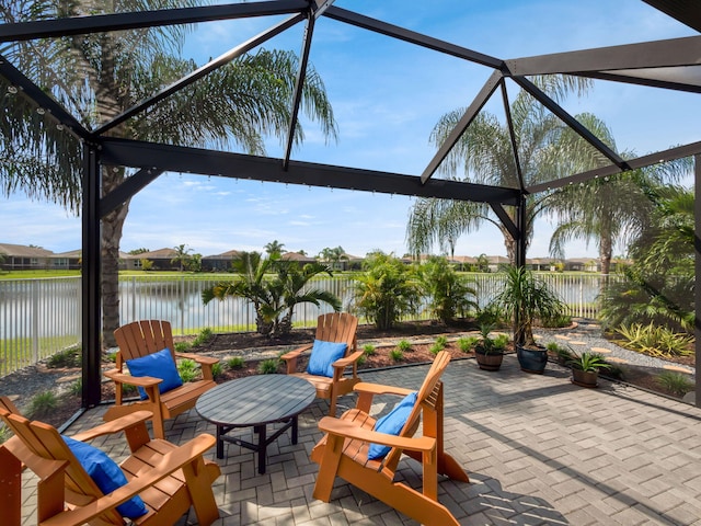 view of patio with a water view and glass enclosure