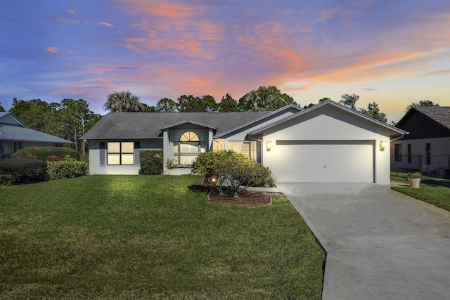 view of front of property featuring a garage and a lawn