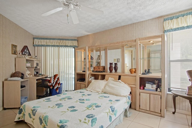 bedroom with ceiling fan, a textured ceiling, and light tile patterned floors