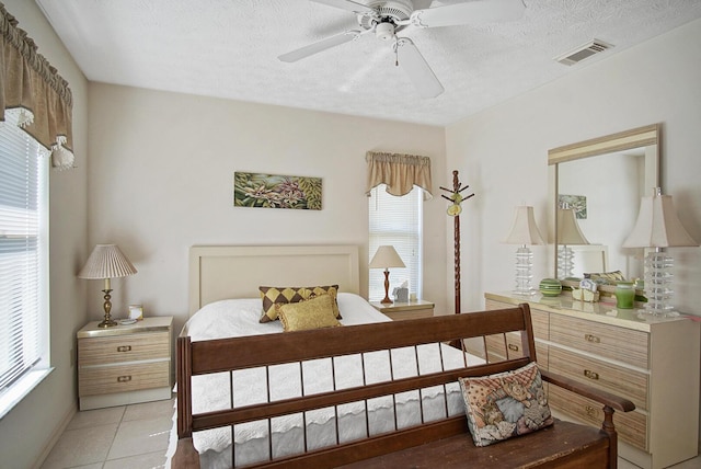 bedroom featuring light tile patterned floors, a textured ceiling, and ceiling fan