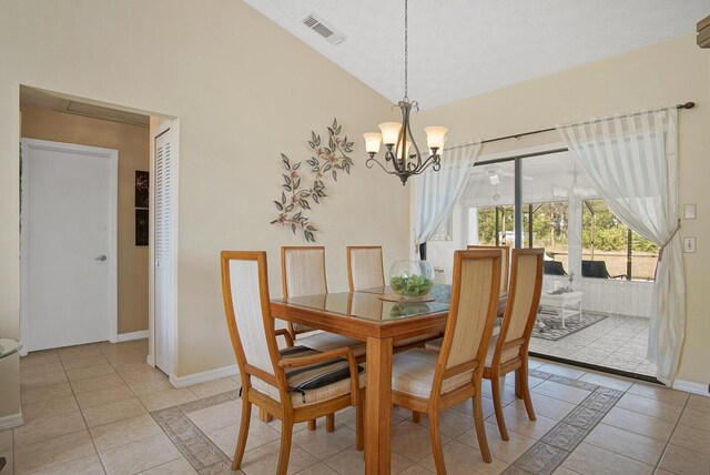 dining space featuring lofted ceiling, light tile patterned floors, and an inviting chandelier