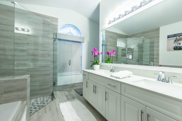 bathroom featuring lofted ceiling, a shower with shower door, and vanity