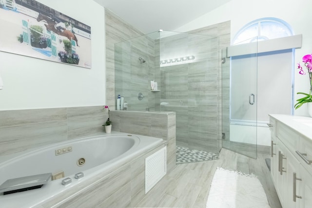 bathroom featuring lofted ceiling, vanity, and plus walk in shower