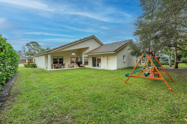 back of property featuring a playground, a patio, and a yard