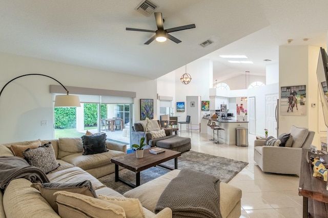 living room featuring vaulted ceiling, light tile patterned floors, and ceiling fan