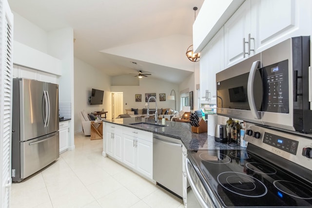 kitchen with sink, appliances with stainless steel finishes, white cabinetry, dark stone countertops, and decorative light fixtures