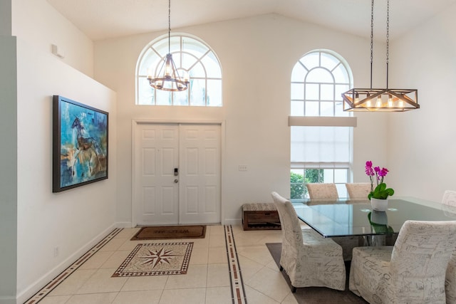 foyer with light tile patterned flooring, high vaulted ceiling, and a notable chandelier