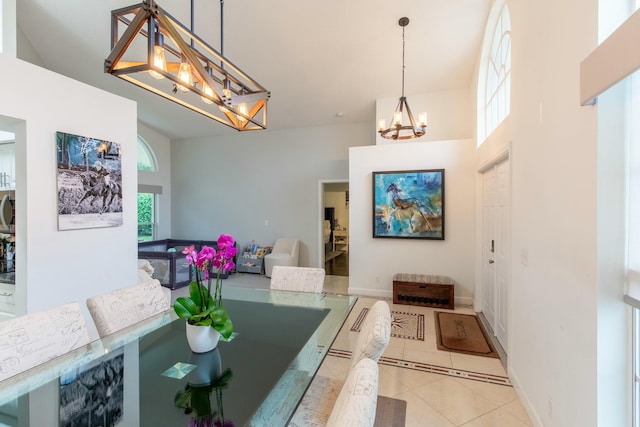 dining room featuring an inviting chandelier, a high ceiling, and light tile patterned floors