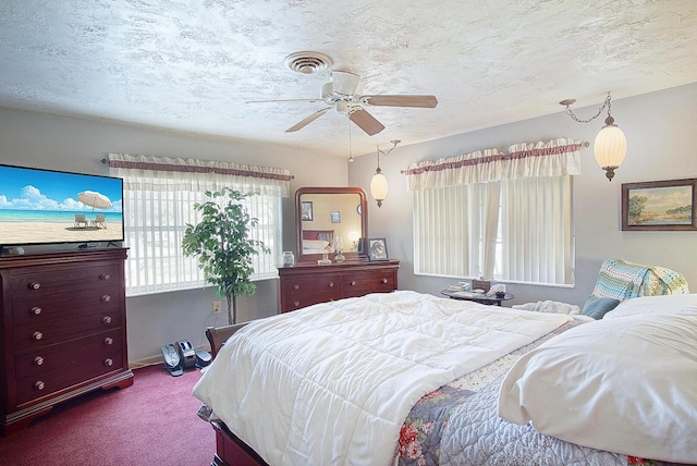 carpeted bedroom with a textured ceiling and ceiling fan