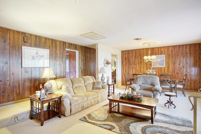 carpeted living room with an inviting chandelier