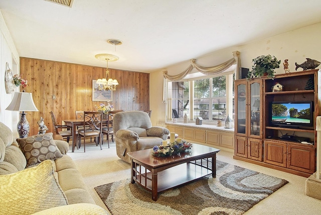 living room featuring light carpet, a notable chandelier, and wood walls