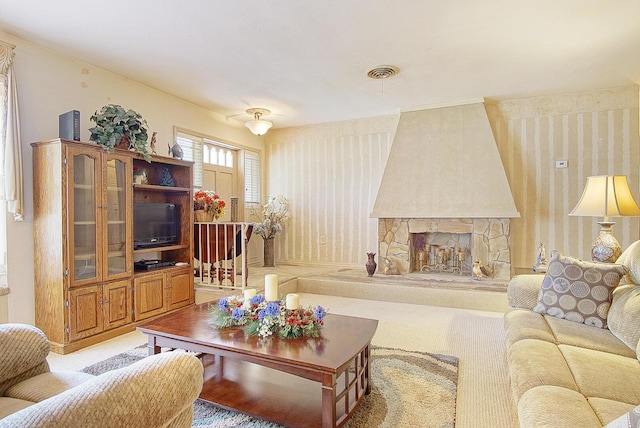 living room with a stone fireplace and light carpet