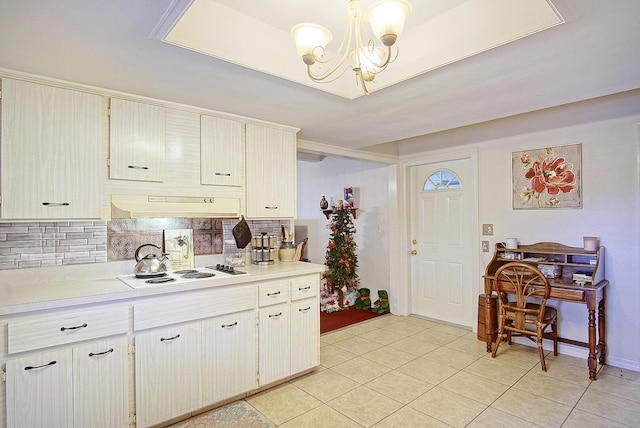 kitchen with pendant lighting, a notable chandelier, white electric cooktop, light tile patterned flooring, and decorative backsplash