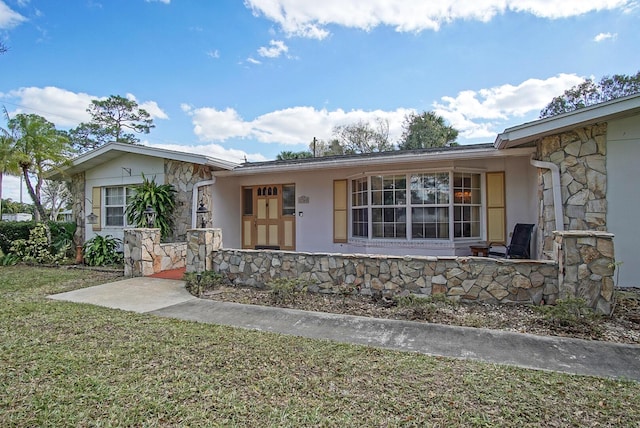 ranch-style house with covered porch and a front yard