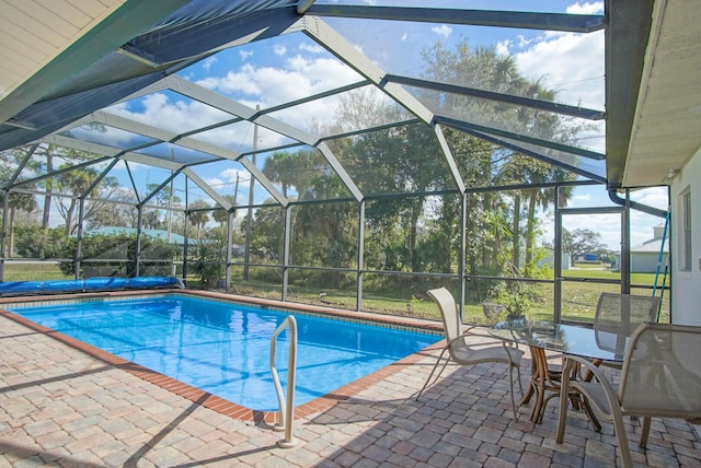 view of swimming pool featuring glass enclosure and a patio area