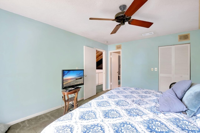 bedroom with ceiling fan, carpet flooring, a closet, and a textured ceiling