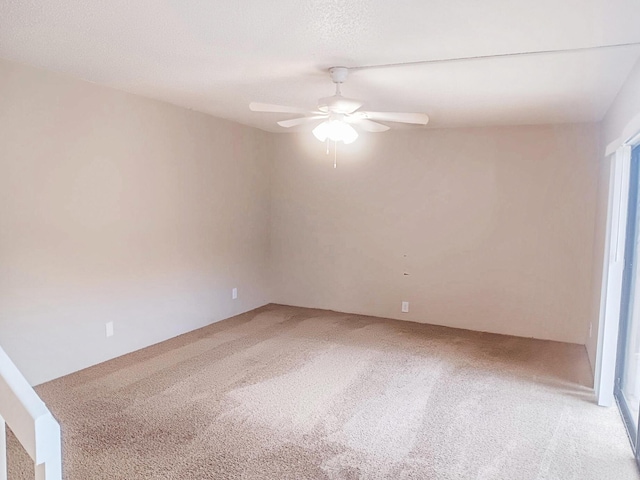 empty room featuring ceiling fan, carpet flooring, and a textured ceiling