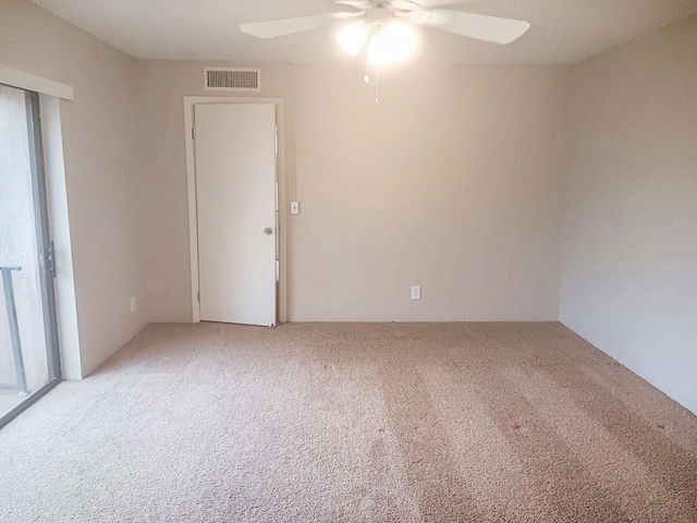 carpeted spare room featuring ceiling fan