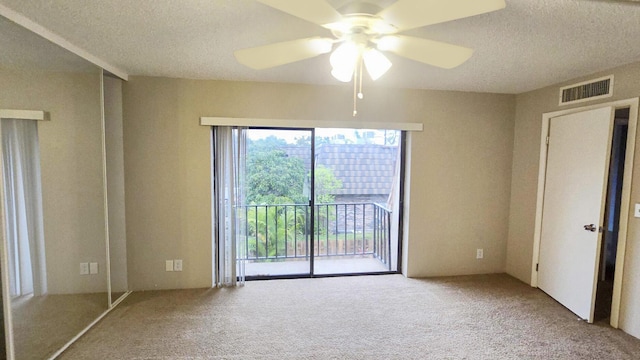 unfurnished bedroom with light carpet, access to exterior, a textured ceiling, and ceiling fan