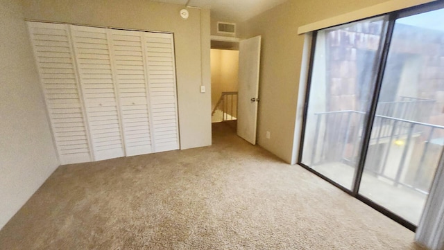 unfurnished bedroom featuring light colored carpet and a closet