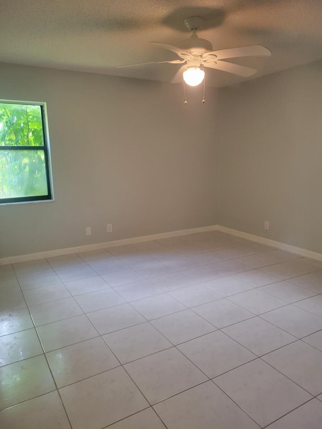 unfurnished room with ceiling fan, a textured ceiling, and light tile patterned flooring