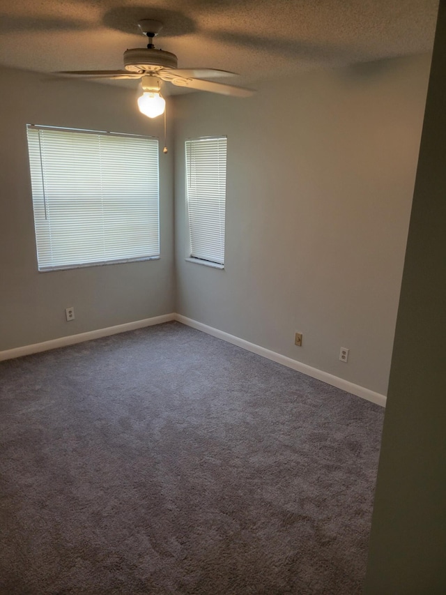 carpeted spare room featuring ceiling fan and a textured ceiling