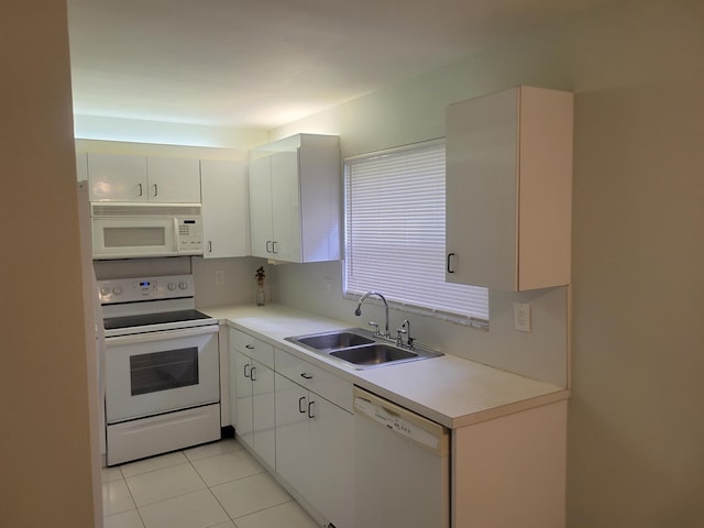 kitchen with light tile patterned flooring, sink, tasteful backsplash, white appliances, and white cabinets