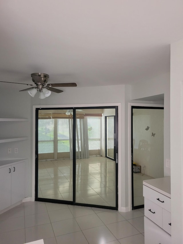 interior space with light tile patterned floors and ceiling fan