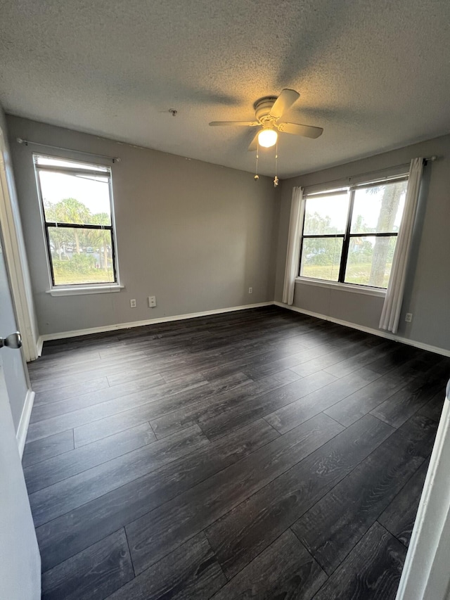 spare room featuring ceiling fan, dark hardwood / wood-style floors, and a textured ceiling