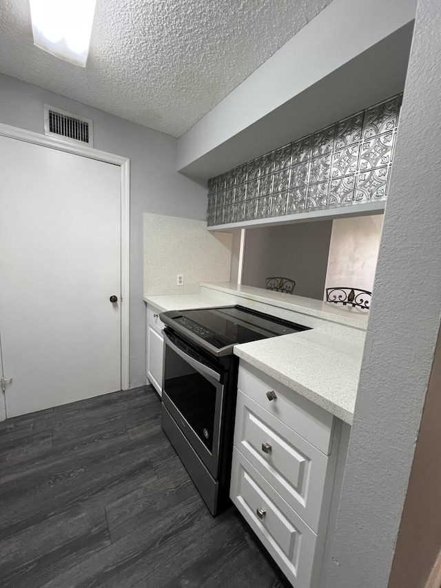 kitchen featuring white cabinetry, backsplash, dark wood-type flooring, a textured ceiling, and electric stove