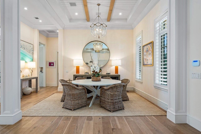 dining space featuring beamed ceiling, ornamental molding, a chandelier, and light hardwood / wood-style floors