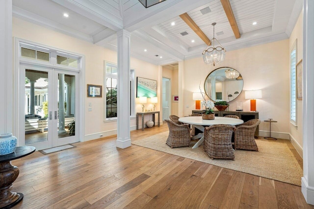 dining space featuring beam ceiling, light hardwood / wood-style floors, and ornate columns