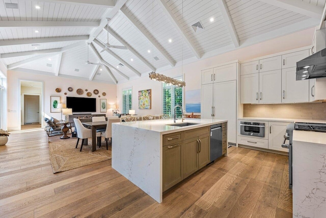 kitchen featuring sink, appliances with stainless steel finishes, white cabinetry, an island with sink, and decorative backsplash