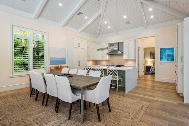 dining room with sink, wood ceiling, beam ceiling, high vaulted ceiling, and light hardwood / wood-style floors