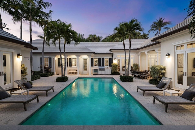 pool at dusk with a patio