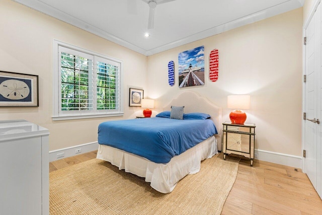 bedroom featuring crown molding, ceiling fan, and light wood-type flooring