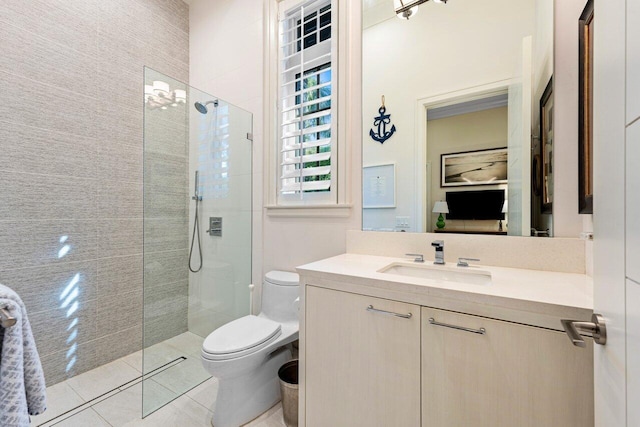 bathroom with tiled shower, vanity, toilet, and tile patterned flooring