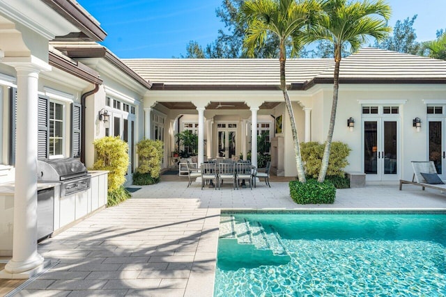 view of pool featuring exterior kitchen, a patio, a grill, and french doors