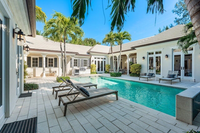 view of swimming pool featuring a patio area and french doors