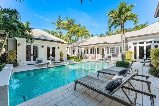 view of pool featuring a patio, french doors, and pool water feature