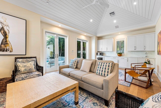 living room featuring a wealth of natural light, wooden ceiling, and french doors