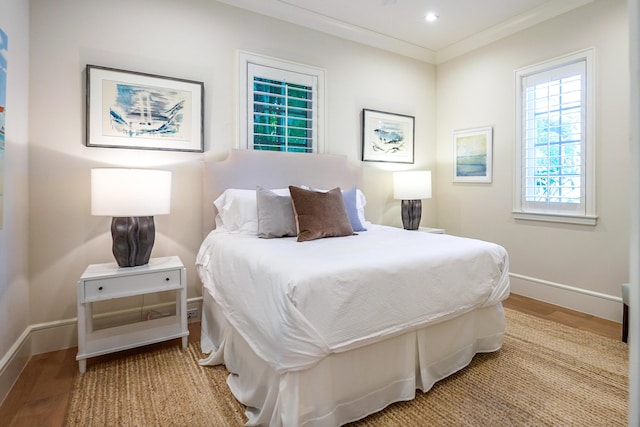 bedroom with ornamental molding and light wood-type flooring